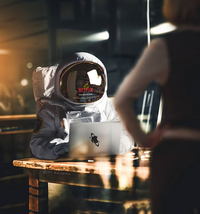 astronaut in a bar using laptop